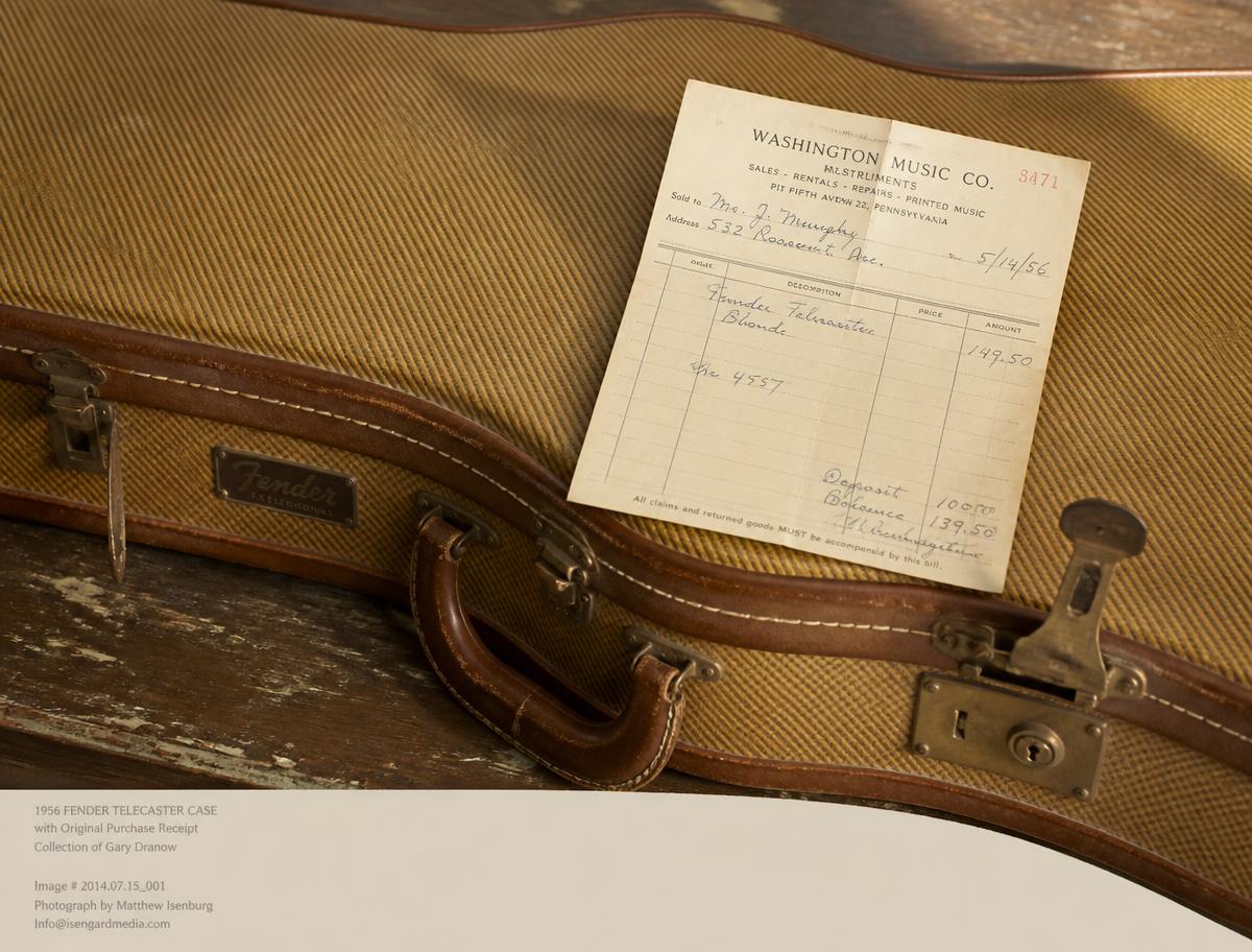 A vintage tweed guitar case with an original handwritten purchase receipt