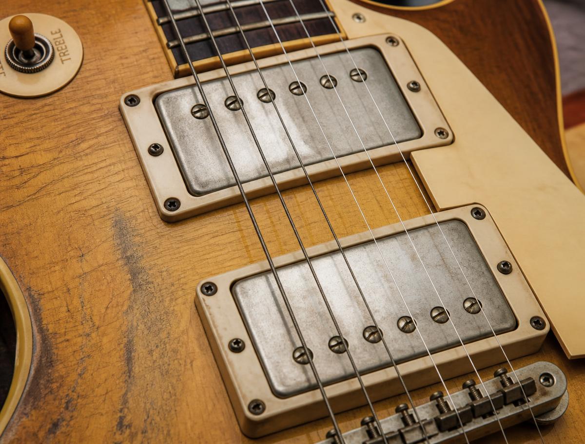 Close-up of vintage humbucker pickups on an aged guitar top